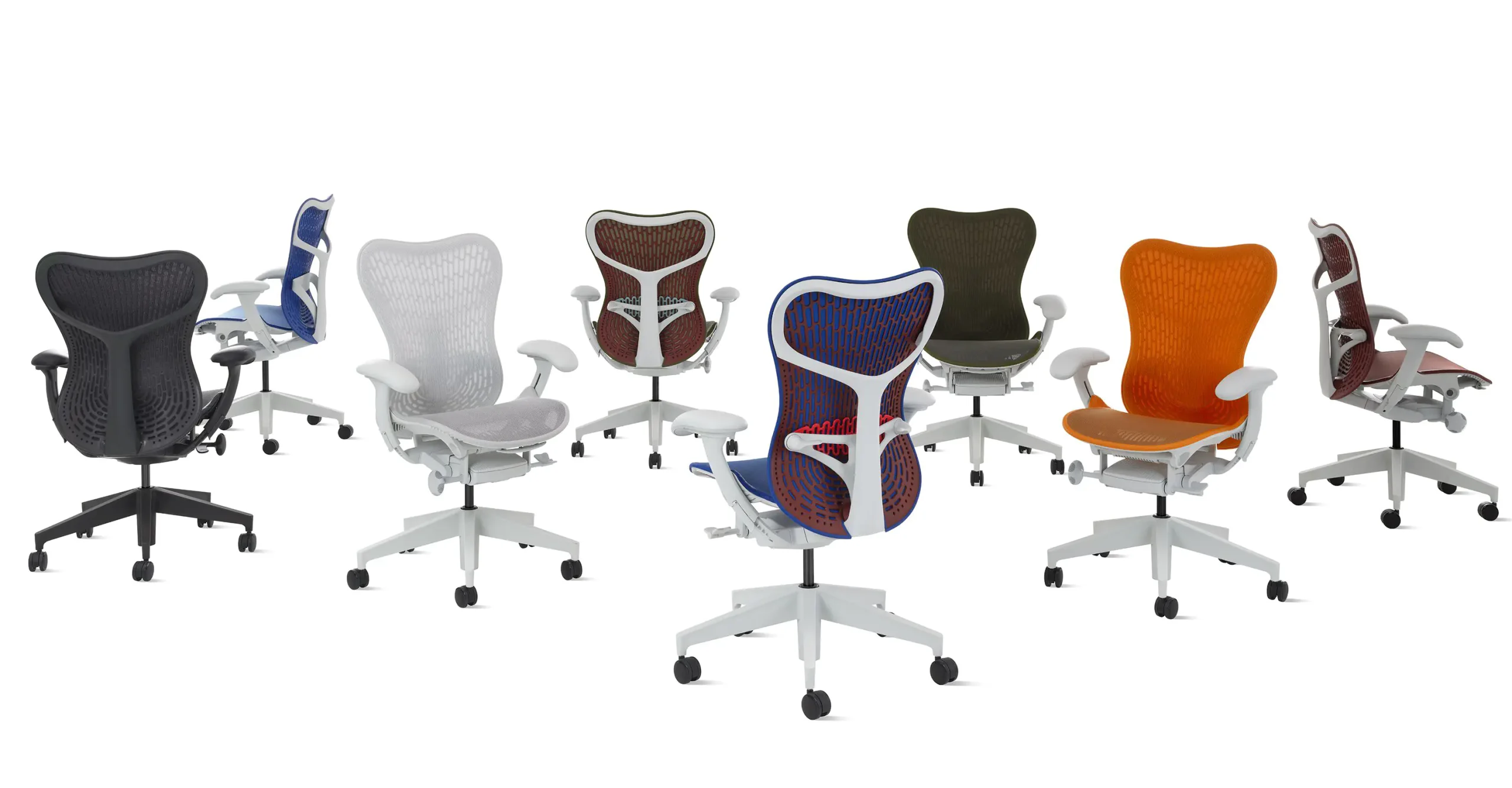 Een rij ergonomische bureaustoelen, waaronder de stijlvolle Mirra 2, toont levendige kleuren zoals blauw, grijs, rood, groen en oranje. Elke stoel heeft een mesh rugleuning en een wit frame met wielen. Perfect gerangschikt in een halve cirkel op een witte achtergrond, benadrukken deze stoelen hun unieke kenmerken.