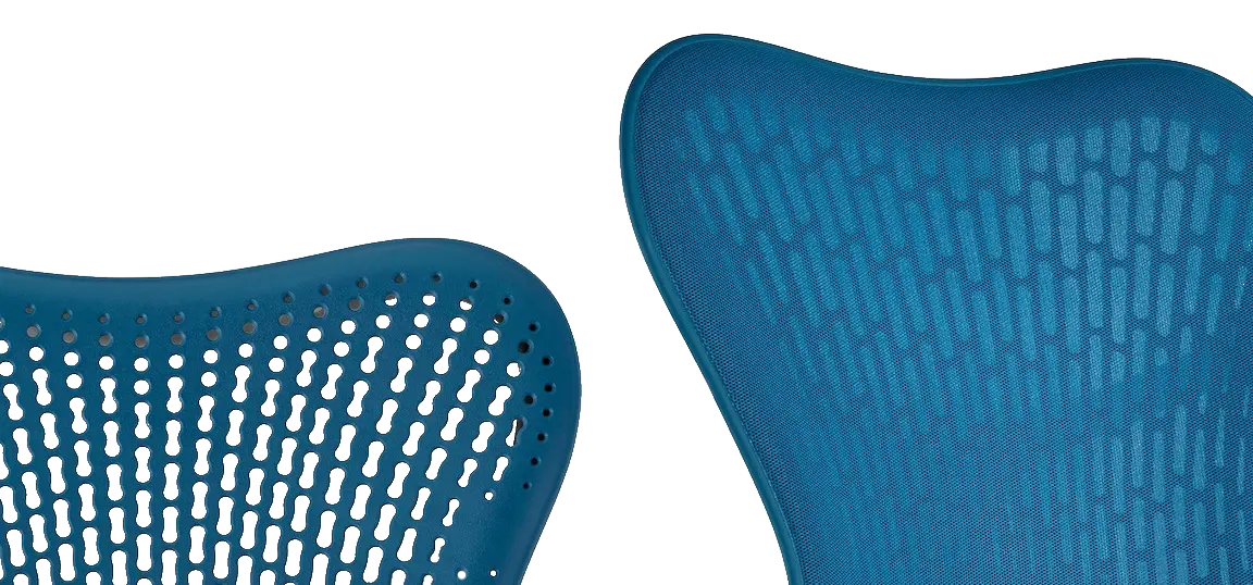 Close-up van twee moderne Herman Miller stoelruggen in het blauw. De linkerstoel heeft een geometrisch, geperforeerd patroon, terwijl de rechterstoel een solide, gestructureerd oppervlak heeft. Beide hebben gebogen, ergonomische vormen tegen een witte achtergrond.