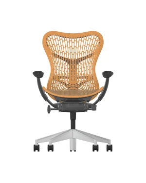 De Herman Miller Mirra 2 in Ochre heeft een TriFlex Rug tan mesh rugleuning en zitting, met verstelbare zwarte armleuningen. Het heeft een strak grafiet frame op een geüpgrade aluminium draaivoet met vijf zwenkwielen, gemarkeerd tegen een witte achtergrond.