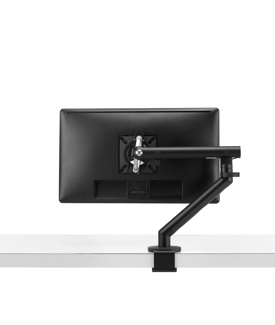 Achteraanzicht van een computermonitor gemonteerd op een Herman Miller Flo Monitor Arm (3 tot 9 kg, enkele opstelling), bevestigd aan een wit bureau voor flexibele positionering, met een effen witte achtergrond.