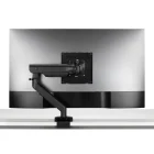 Een Herman Miller Flo X monitorarm ondersteunt een monitor op een wit bureau en biedt flexibele positionering dankzij het strakke, zwarte, verstelbare ontwerp voor een minimalistische, ergonomische opstelling.