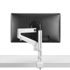 Een zwarte computermonitor is gemonteerd op een Herman Miller Lima Monitorarm (0 tot 6,5 kg, enkele/duo-opstelling) die aan een smetteloos wit bureau is bevestigd. Hierdoor is de monitor flexibel te positioneren en worden kabels netjes weggewerkt.