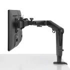 Een Herman Miller Ollin Monitor Arm, in het zwart, is gemonteerd op een wit bureau om een flat-panel display te bevestigen. Ideaal voor enkele of duo-opstellingen, biedt meerdere verbindingen om de ergonomie van de werkplek te verbeteren en ondersteunt gewichten van 0 tot 9 kg.