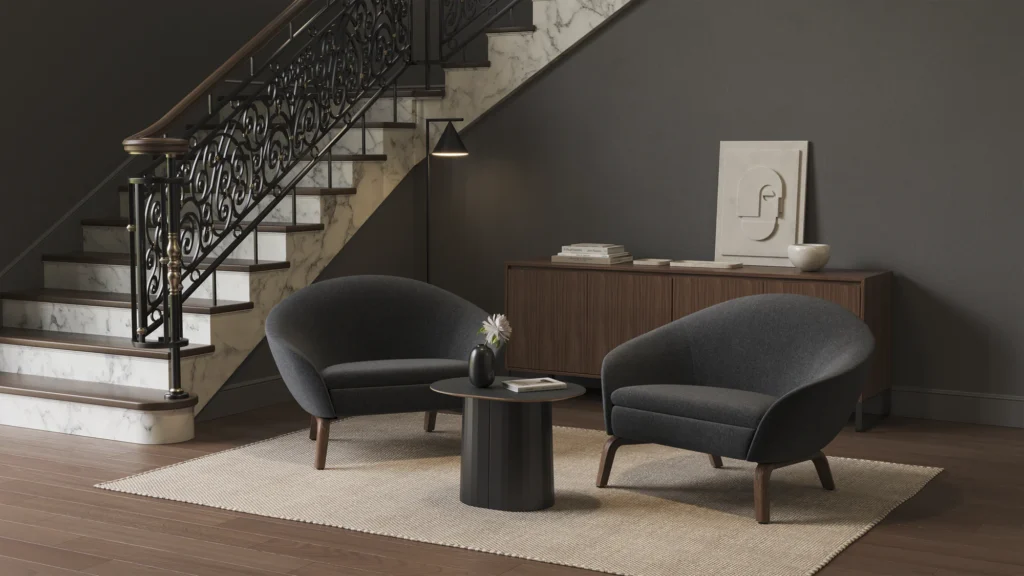 Een moderne woonkamer heeft twee donkere NaughtOne fauteuils rond een kleine ronde tafel met een vaas, op een licht tapijt - een ideale B2B ontmoetingsruimte. Daarachter staat een houten dressoir met minimalistisch decor en een trap met een donkere sierlijke leuning. Een moderne woonkamer heeft twee donkere NaughtOne fauteuils rond een kleine ronde tafel met een vaas, op een licht tapijt - een ideale B2B ontmoetingsruimte. Daarachter staat een houten dressoir met minimalistisch decor en een trap met een donkere sierlijke leuning.